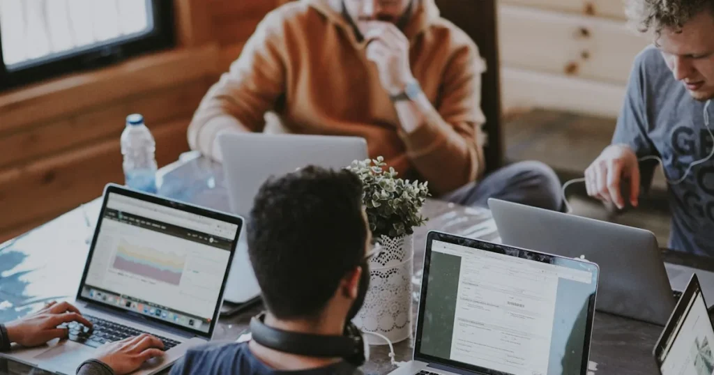 Reunión de equipo en oficina con computadoras y tecnología